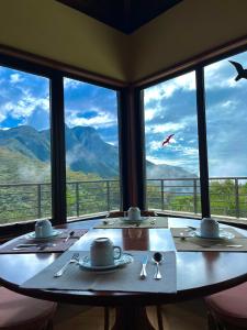 a table in a restaurant with a view of mountains at Hotel São Gotardo in Itamonte