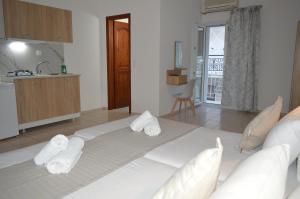 un grande letto bianco in una stanza con asciugamani di Junction studios a Città di Skiathos