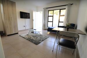 a living room with a table and chairs and a couch at Casa Decha in Windhoek