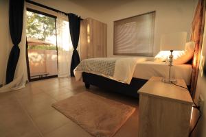 a bedroom with a bed and a large window at Casa Decha in Windhoek