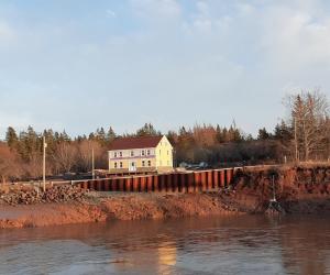 a house behind a fence next to a river at Mountainview Solitude Inn in Riverside