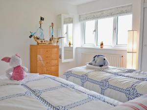 a bedroom with two beds with stuffed animals on them at Galleons Reach in Instow