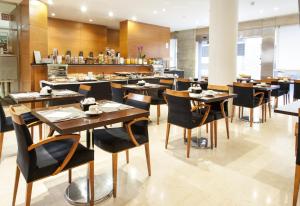 un restaurante con mesas y sillas y un bar en Zenit Málaga, en Málaga