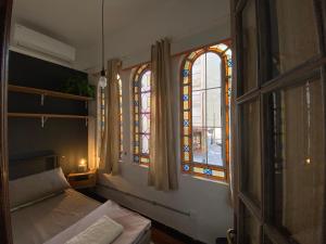 una camera con letto e vetrate istoriate di Youki Haus Hostel a Montevideo
