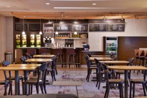 a restaurant with wooden tables and chairs and a bar at Courtyard by Marriott Ocala in Ocala