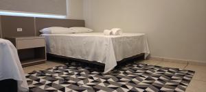 a room with a bed with a black and white floor at Hotel Pires Faxinal in Faxinal