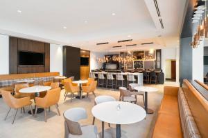 un restaurante con mesas y sillas y un bar en Mystic Marriott Hotel and Spa, en Groton