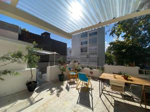 - une terrasse avec une table et des chaises dans un bâtiment dans l'établissement Youki Haus Hostel, à Montevideo