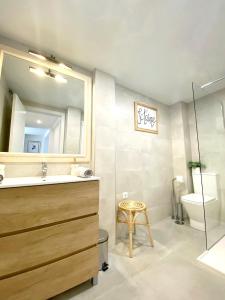 Un baño con lavabo, espejo e inodoro. en Casa La Victoria, en Málaga