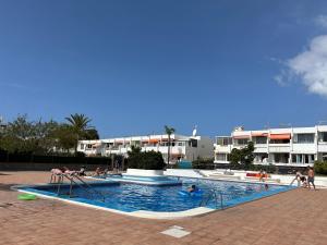 a swimming pool with people playing in the water at Practical and cozy apartment in southern Arona in Arona