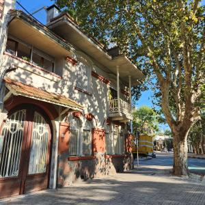 um edifício com uma varanda e uma árvore numa rua em Youki Haus Hostel em Montevidéu