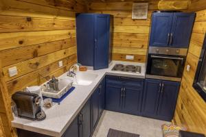 a kitchen with blue cabinets and a sink at أكواخ غيم ومطر in Al Hada