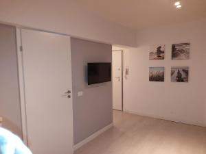 Dieses weiße Zimmer verfügt über einen TV und eine Wand. in der Unterkunft OldTown Studio in Bukarest