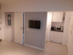 ein Zimmer mit einer Tür und einem Fernseher an der Wand in der Unterkunft OldTown Studio in Bukarest