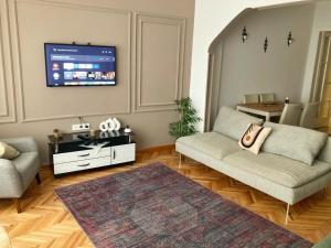 uma sala de estar com um sofá e uma televisão de ecrã plano em Şişli House em Istambul