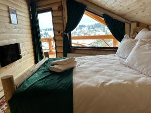 a bedroom with a large bed with a large window at Yanis Chalet Dorna in Vatra Dornei