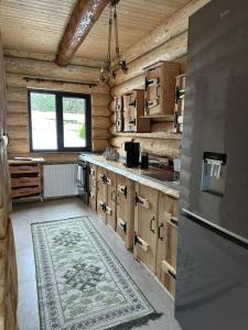 kuchnia z drewnianymi szafkami i dywanem na podłodze w obiekcie Yanis Chalet Dorna w mieście Vatra Dornei