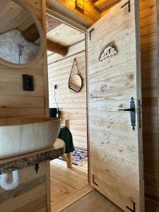 a bathroom with a sink and a wooden wall at Yanis Chalet Dorna in Vatra Dornei