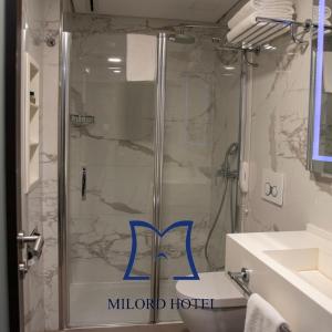 La salle de bains est pourvue d'une douche avec une porte en verre. dans l'établissement Milord Hotel, à Istanbul