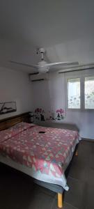 a bedroom with a bed and a ceiling fan at Les Flots Bleus in La Trinité