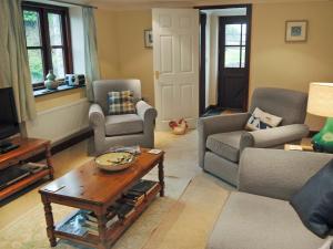 a living room with couches and a coffee table at Prideaux Cottage in Luxulyan