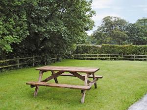 a wooden picnic table sitting in the grass at Prideaux Cottage in Luxulyan