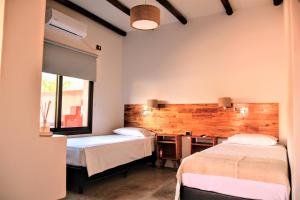 a bedroom with two beds and a desk and a window at WAYTAY in Cafayate