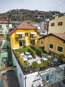 Elle offre une vue aérienne sur une maison jaune dotée d'une terrasse. dans l'établissement Residence Rösch, à Merano