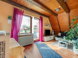 uma sala de estar com cortinas cor-de-rosa e uma janela grande em Cozy holiday apartment with balcony near the lake em Plön