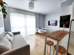 uma sala de estar com um sofá e uma mesa em Triana Suite Torre Sevilla, parking free gratis! em Sevilha