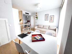 sala de estar con mesa blanca y sillas en Triana Suite Torre Sevilla, parking free gratis!, en Sevilla