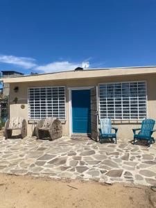 uma casa com duas cadeiras e uma porta azul em Finca Rositas em Valle de Guadalupe