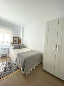 a white bedroom with a bed and a closet at Casa La Victoria in Málaga