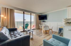 una sala de estar con un sofá y una mesa en 0509 Oceanfront Getaway by Atlantic Towers, en Carolina Beach 16 fotos más