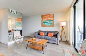 a living room with a couch and a table at 0311 Seaside Retreat by Atlantic Towers in Carolina Beach