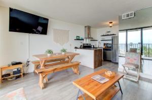 a living room with a table and a kitchen at 0311 Seaside Retreat by Atlantic Towers in Carolina Beach