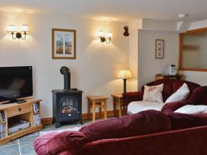 a living room with a couch and a fire place at Nightingales in Kentisbeare