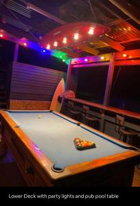 a pool table in a room with purple lights and a pool table at 5 OClock Somewhere 6BR sleeps 18 with Kids Retreat in Port Macquarie