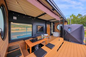 a train car with a table and a tv on a deck at Piilo asobi&stay in Yamanakako