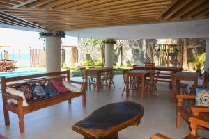 eine Terrasse mit Tischen, Stühlen und einem Sofa in der Unterkunft Na praia - Elegance 202 Luxo - Lateral in Natal