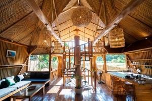 uma sala de estar em plano aberto com um grande tecto de madeira em Palayan Villa - Villa with views, garden and jacuzzi em El Nido