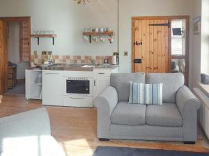 a living room with a couch and a kitchen at Ship Shape in Woodhorn
