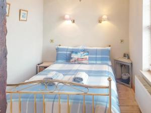 Un pequeño dormitorio con una cama azul y blanca en Ship Shape en Woodhorn