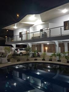 a house with a swimming pool in front of it at night at R&;S Restplace Resort in Matabungkay
