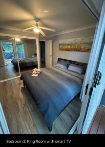 a bedroom with a large bed with a ceiling fan at 5 OClock Somewhere 6BR sleeps 18 with Kids Retreat in Port Macquarie