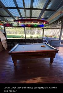 a pool table in the middle of a room at 5 OClock Somewhere 6BR sleeps 18 with Kids Retreat in Port Macquarie