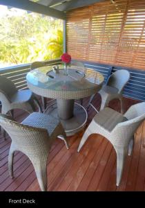 a patio with a table and chairs on a deck at 5 OClock Somewhere 6BR sleeps 18 with Kids Retreat in Port Macquarie