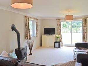 a living room with a couch and a tv at Barrowswood in Cheddar