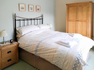 ThrelkeldにあるCropple Howeのベッドルーム1室(ベッド1台、木製ドレッサー付)