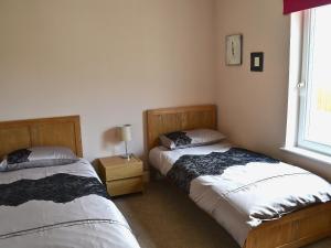 a bedroom with two beds and a window at Bengali in Ringford
